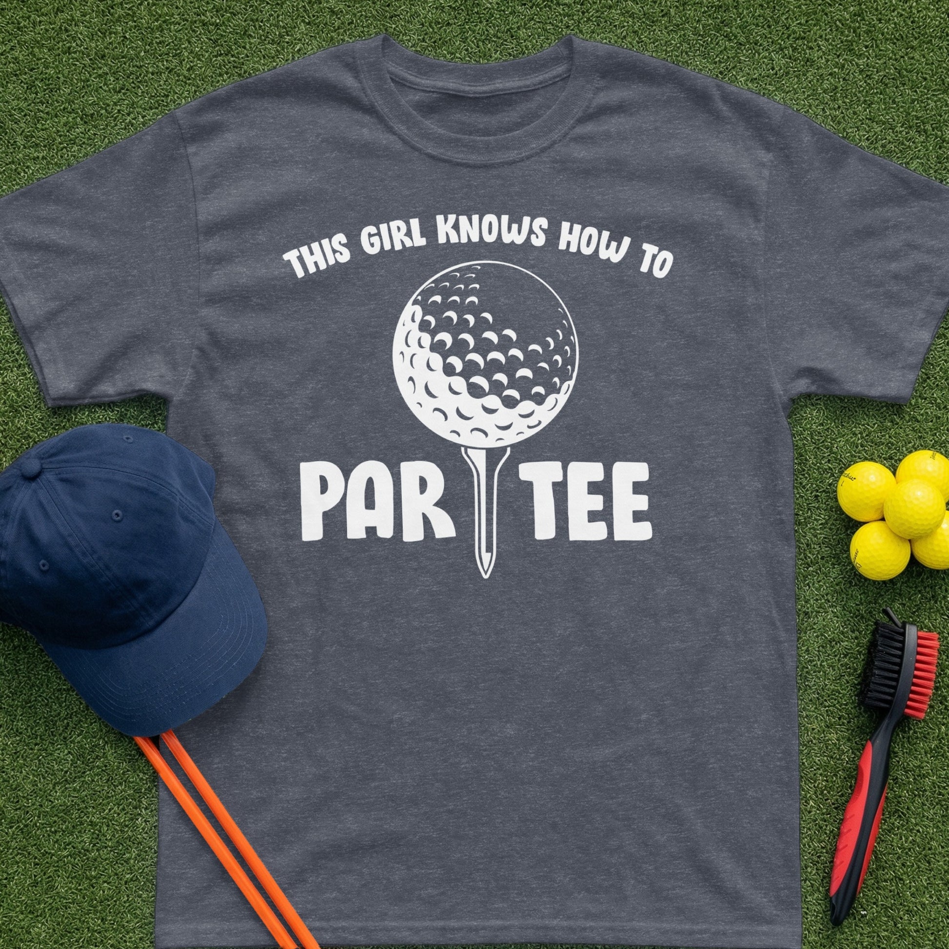 Dark grey t-shirt with "This girl knows how to par tee" graphic and golf items.
