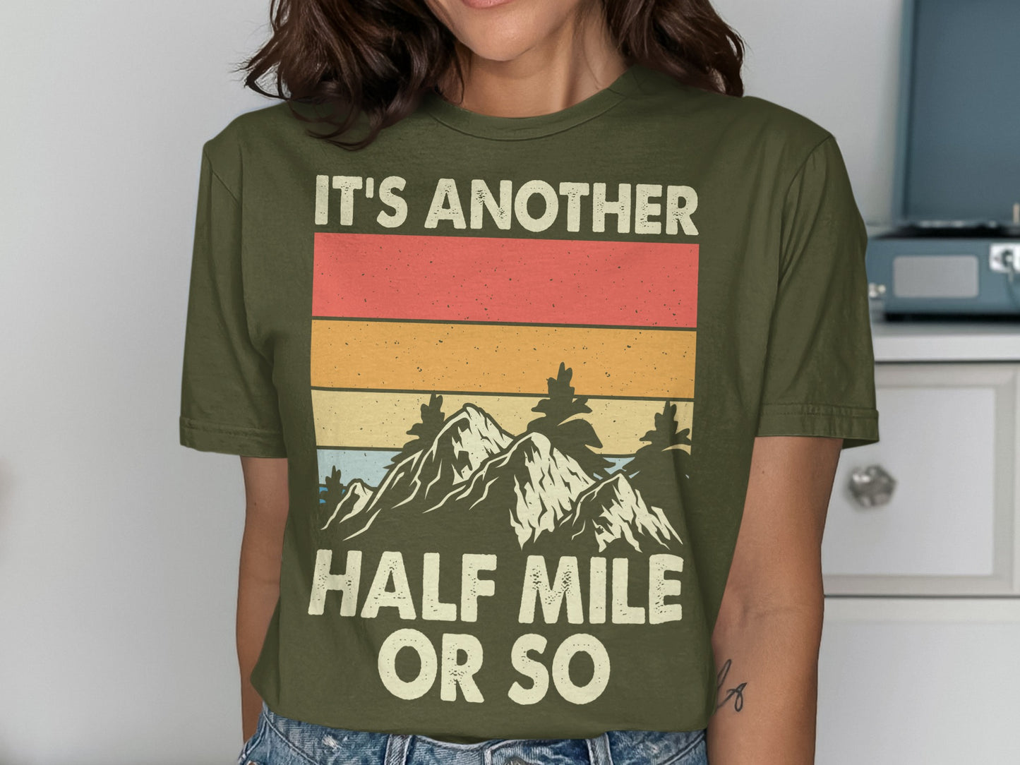 Olive green t-shirt with mountains and "It's Another Half Mile Or So" text.