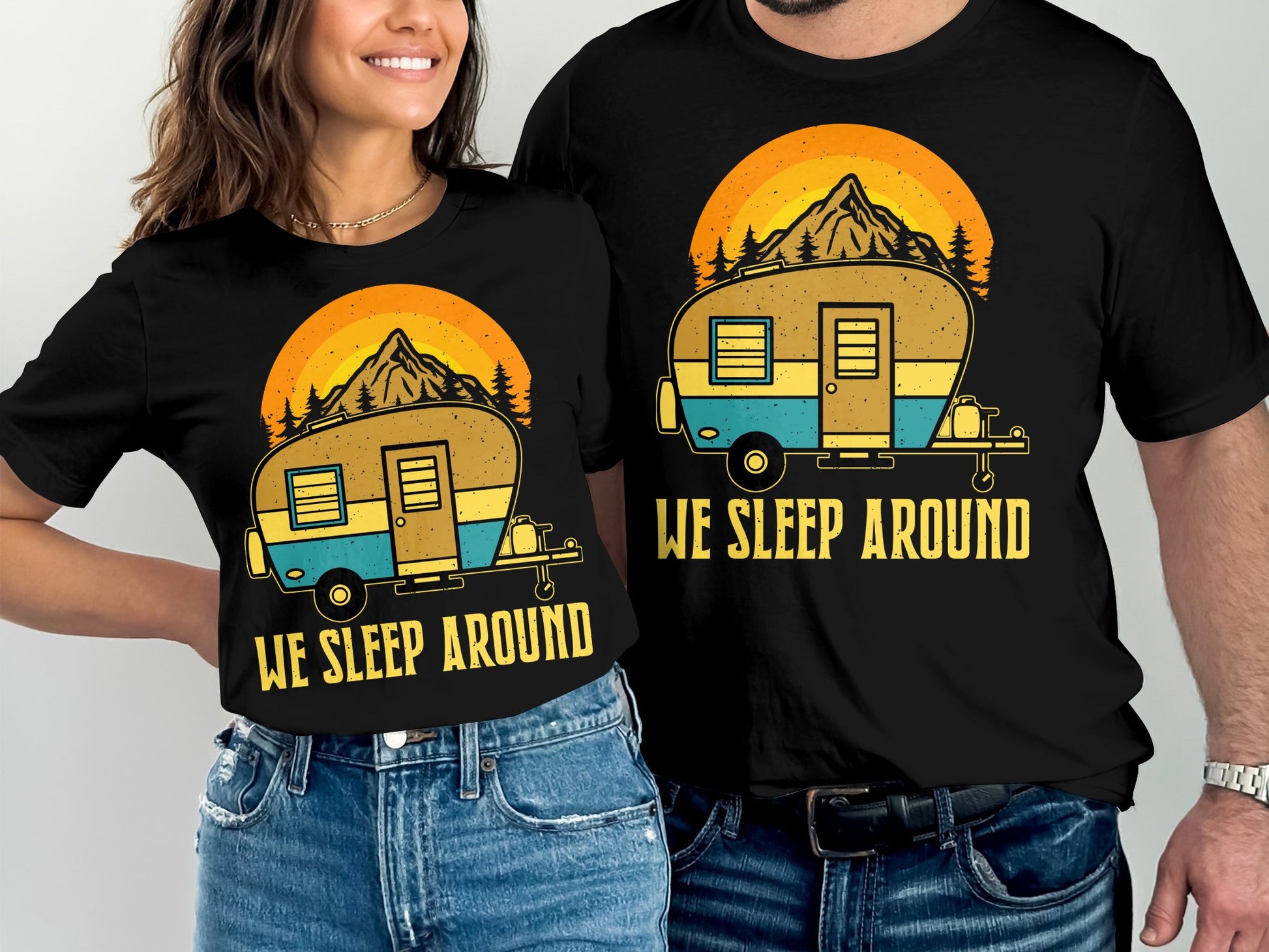 Two people wearing matching "We Sleep Around" camping t-shirts.