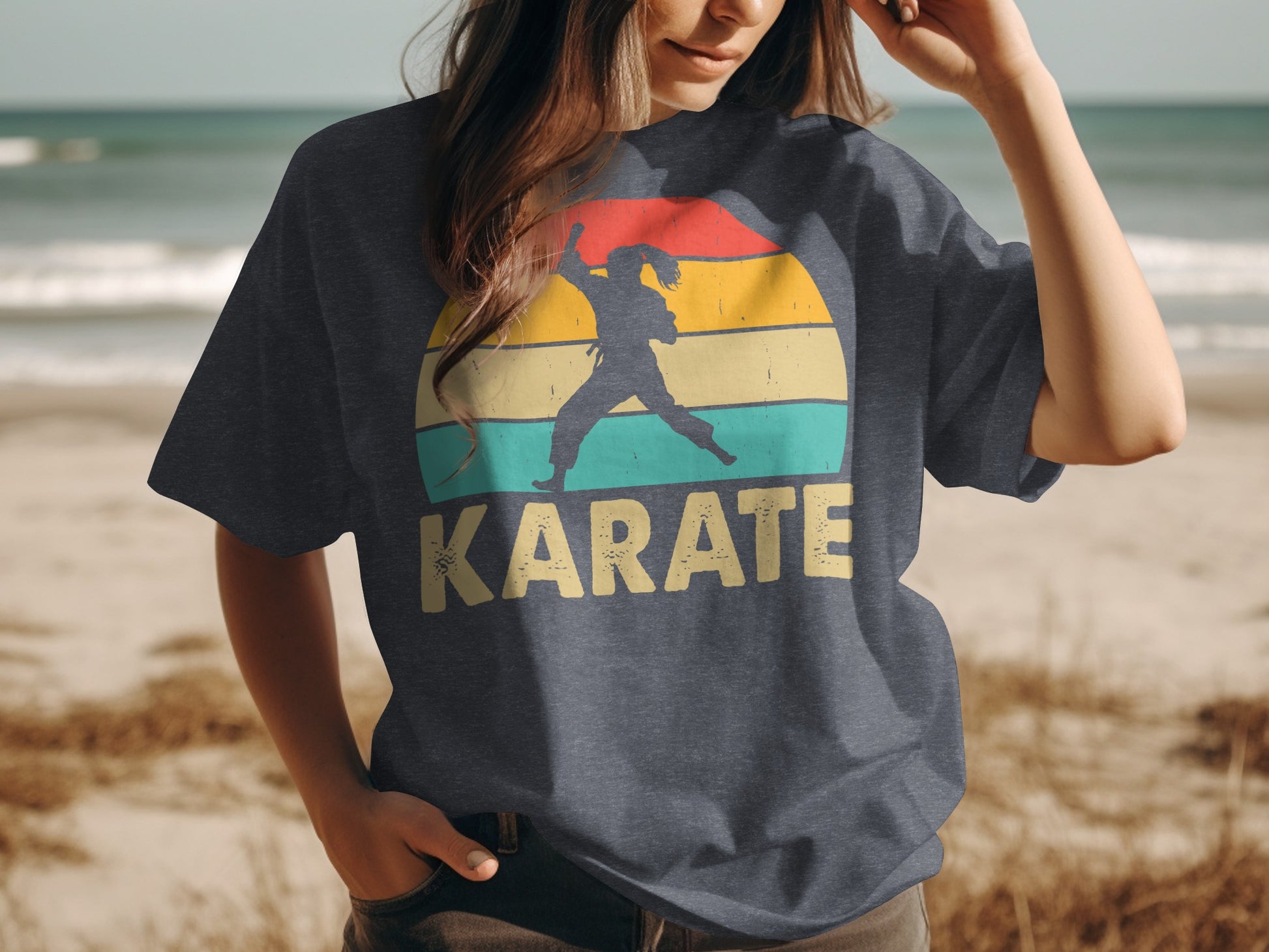 Woman wearing a dark t-shirt with a vintage karate silhouette and sunset design.