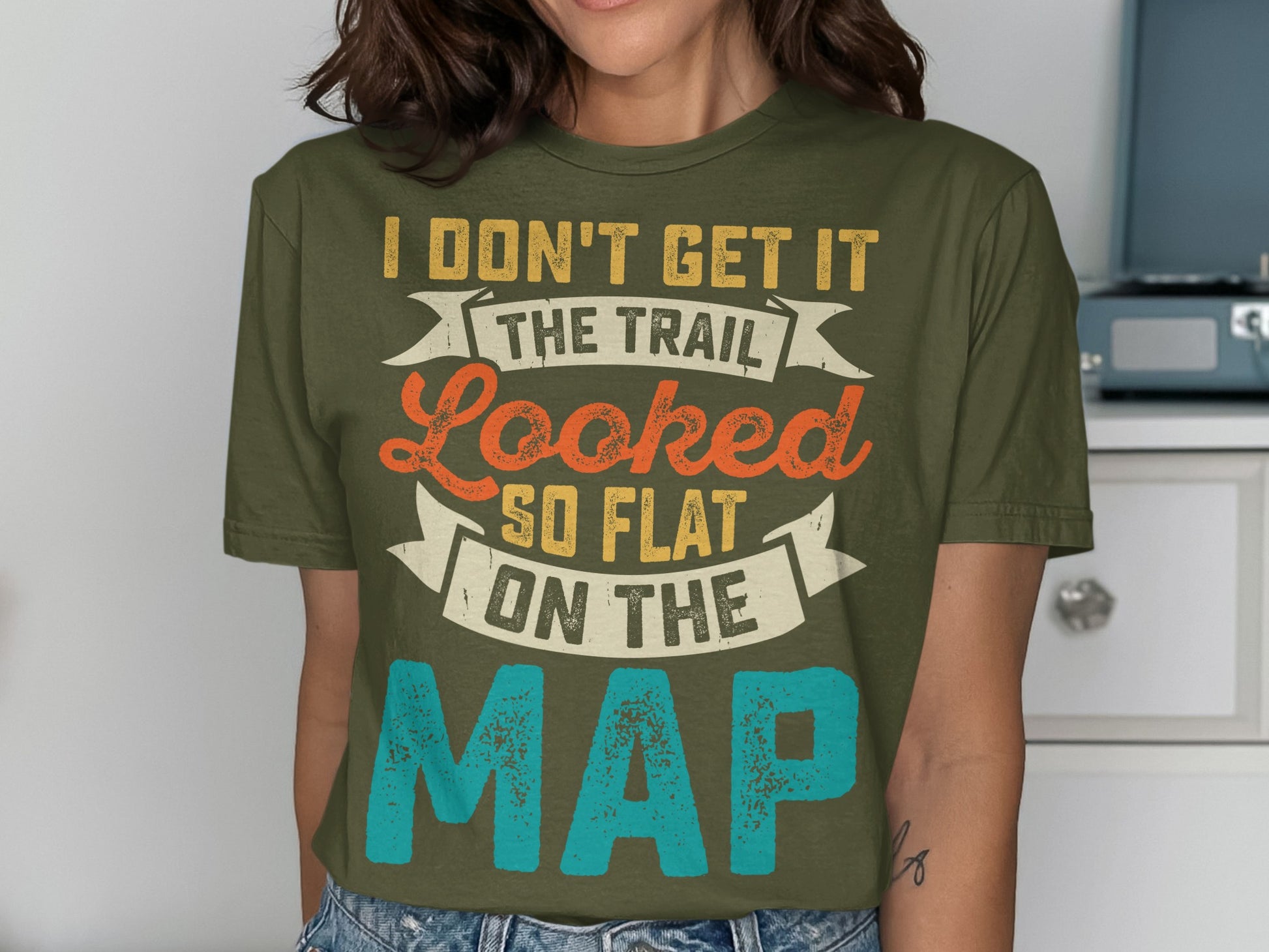Olive green t-shirt with "I don't get it the trail looked so flat on the map" text.