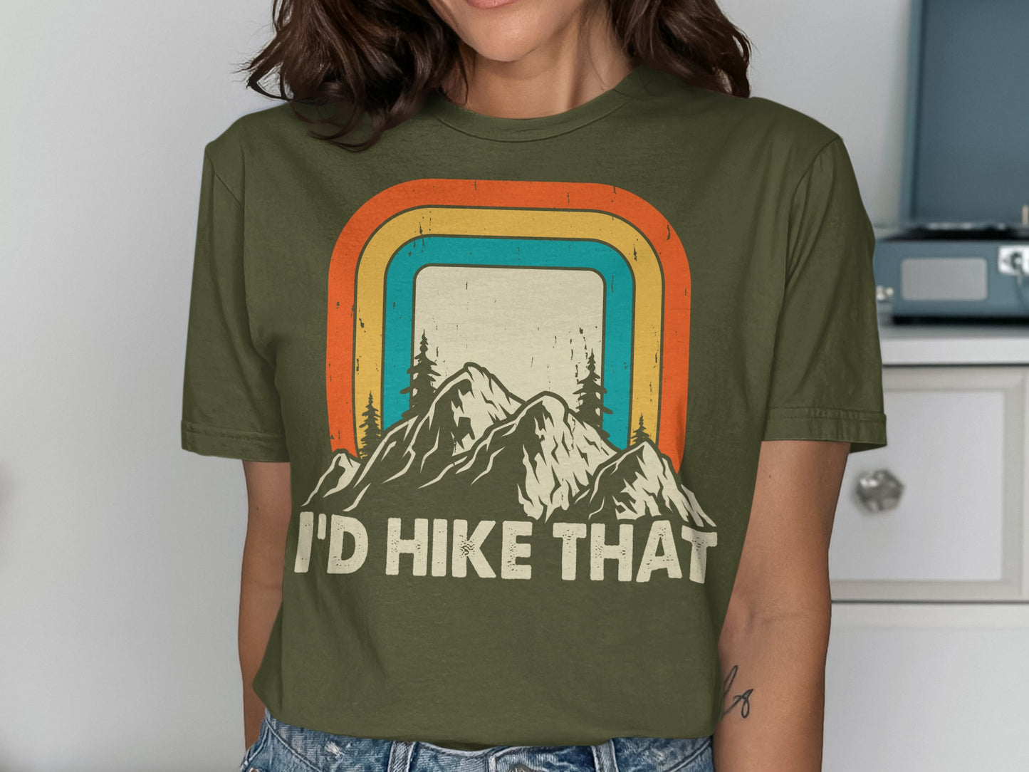Olive green t-shirt with "I'd Hike That" and mountain landscape graphic.