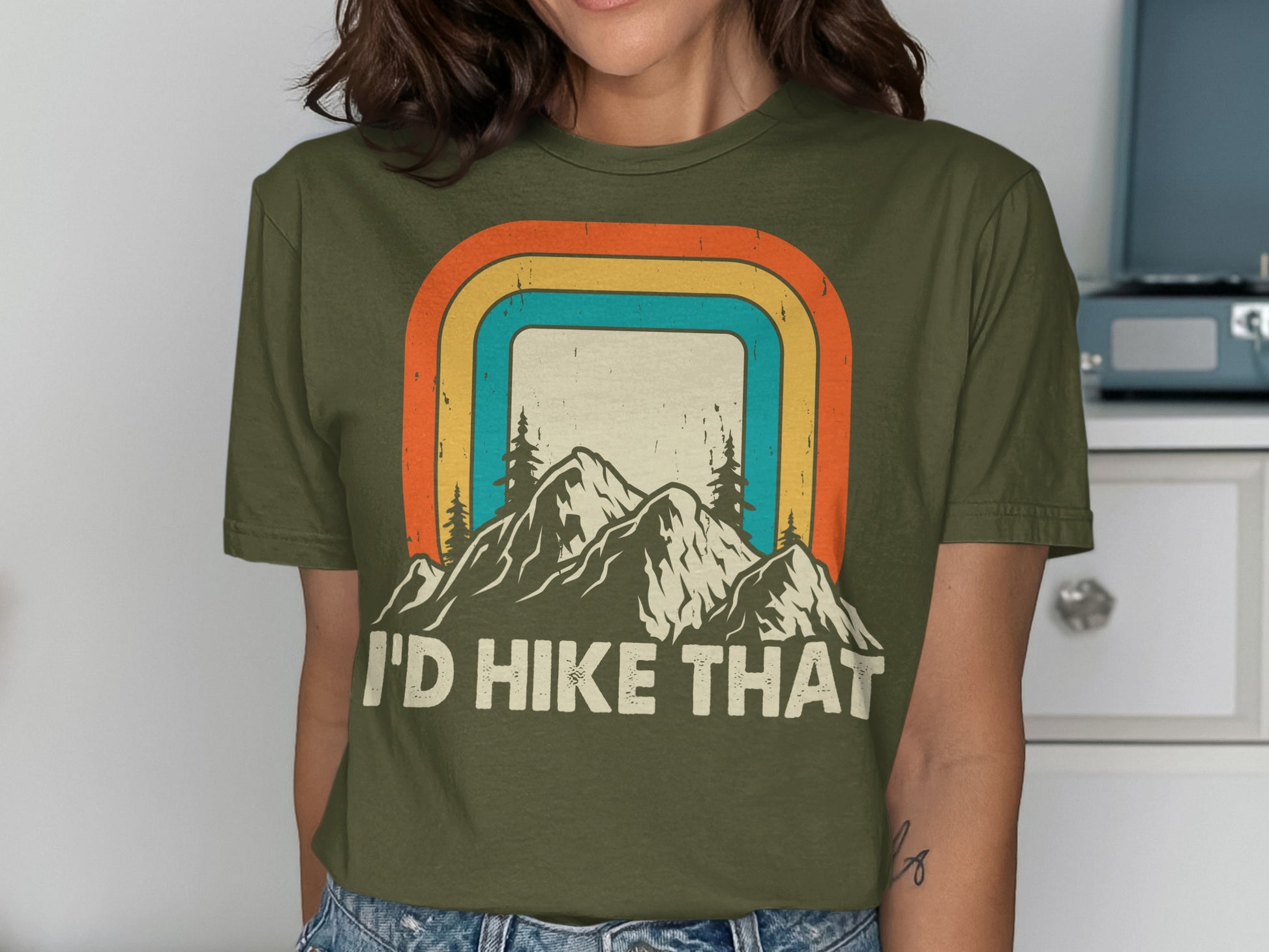 Olive green t-shirt with "I'd Hike That" and mountain landscape graphic.