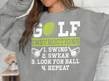 Grey sweatshirt with "GOLF INSTRUCTIONS: 1. SWING 2. SWEAR 3. LOOK FOR BALL 4. REPEAT" text.