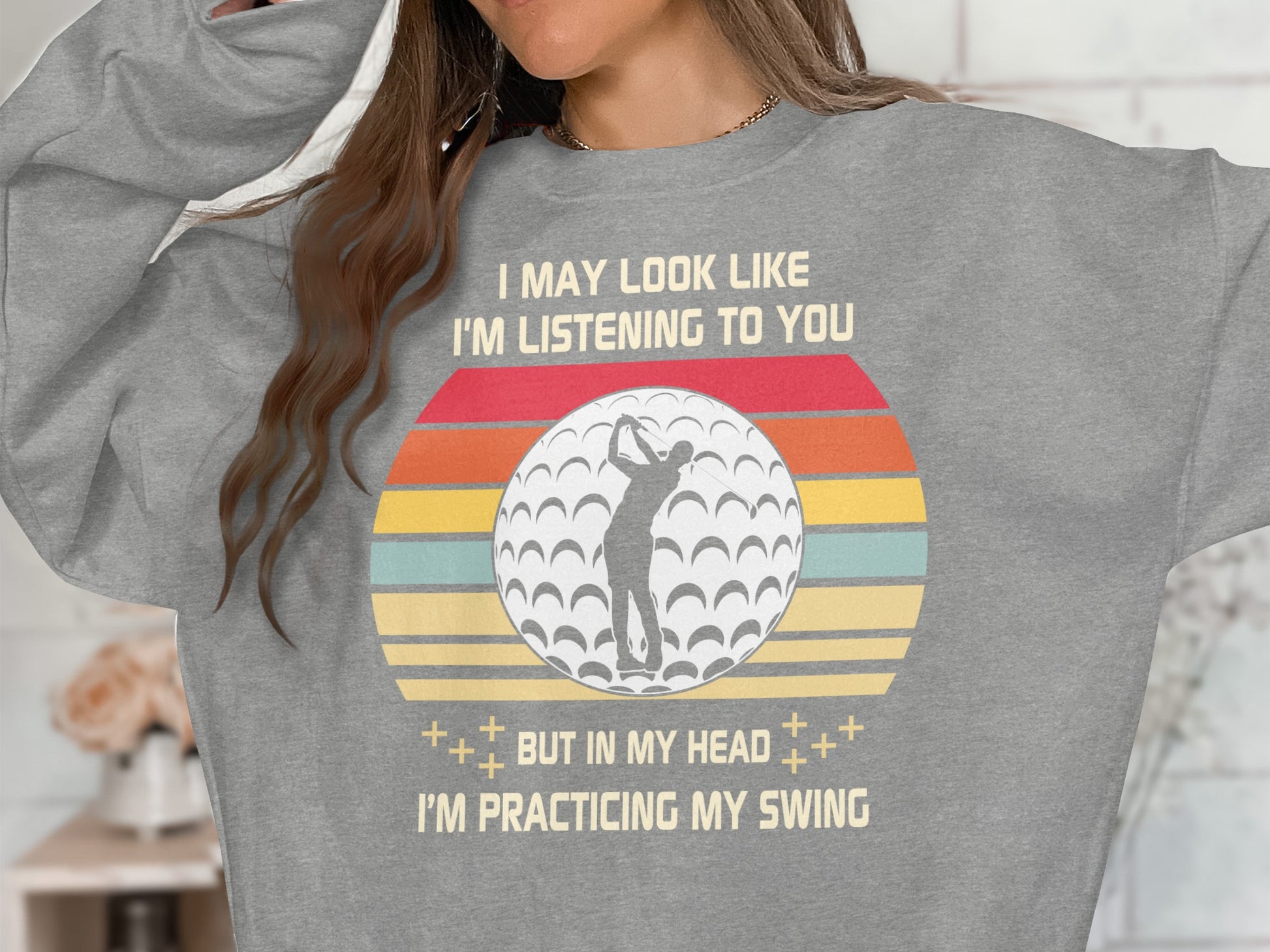 Grey sweatshirt with golf ball, vintage stripes, and "I may look like I'm listening to you, but in my head I'm practicing my swing."