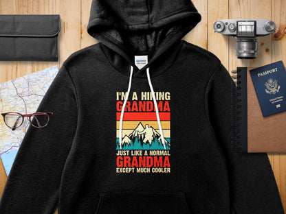 Black hoodie with text "I'M A HIKING GRANDMA JUST LIKE A NORMAL GRANDMA EXCEPT MUCH COOLER".