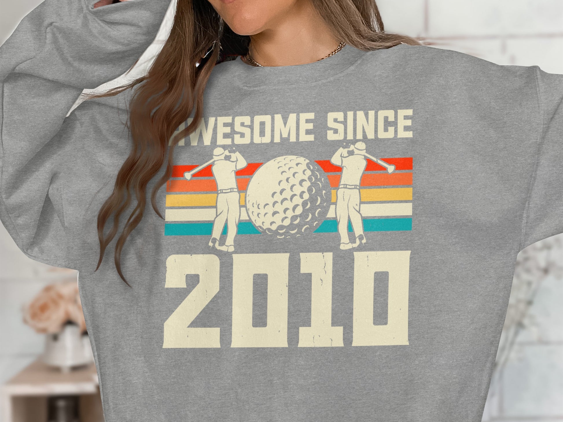 Gray sweatshirt with "Awesome Since 2010" and golf graphic.